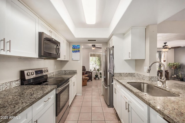 kitchen with sink, ceiling fan, light tile patterned floors, white cabinetry, and stainless steel appliances