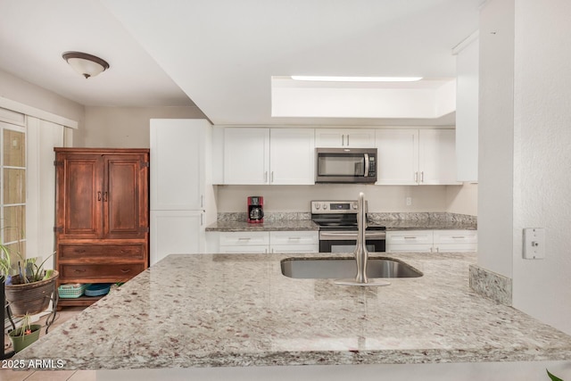 kitchen featuring kitchen peninsula, sink, white cabinetry, and stainless steel appliances