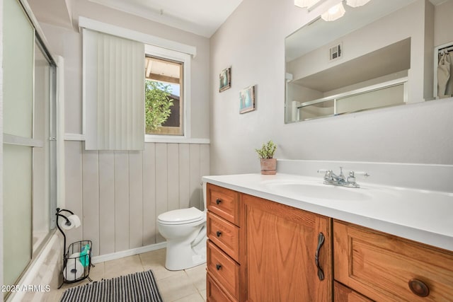 full bathroom featuring tile patterned flooring, vanity, toilet, and combined bath / shower with glass door