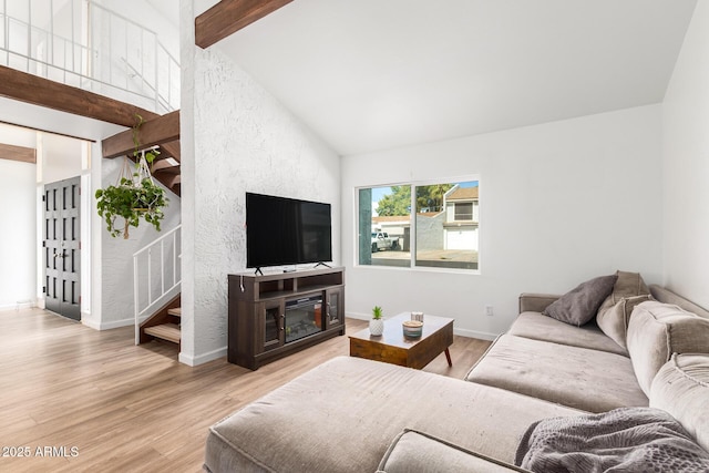 living room with high vaulted ceiling, light hardwood / wood-style floors, and beamed ceiling