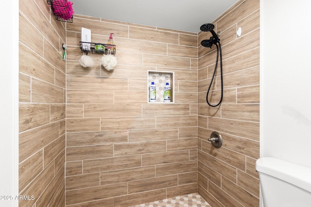 bathroom with toilet and a tile shower