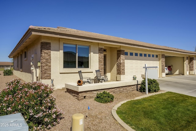 view of front facade with a garage, stone siding, concrete driveway, and stucco siding