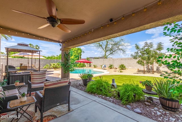 view of patio with ceiling fan, a gazebo, and a fenced in pool