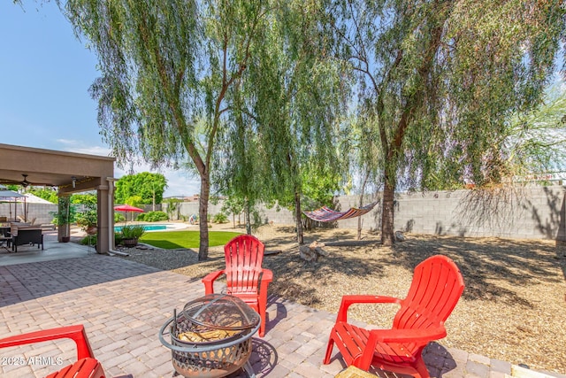 view of patio / terrace with ceiling fan and a fire pit