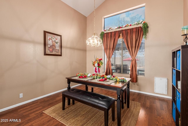 dining room with lofted ceiling, dark hardwood / wood-style floors, and a notable chandelier