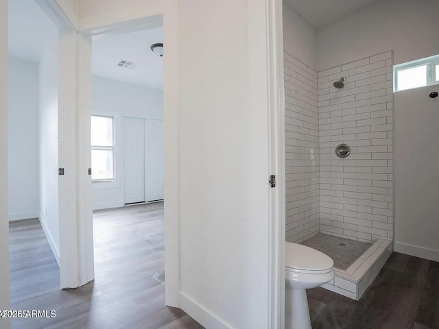 full bathroom with toilet, wood finished floors, visible vents, baseboards, and a stall shower