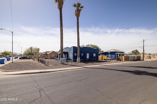 view of front of property featuring a residential view, playground community, and fence