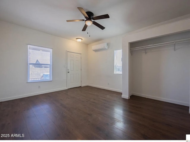 unfurnished bedroom with ceiling fan, baseboards, dark wood finished floors, and a wall mounted air conditioner