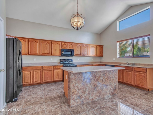 kitchen with hanging light fixtures, an inviting chandelier, black appliances, sink, and a center island