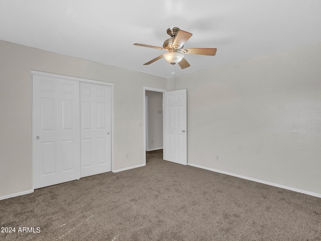 unfurnished bedroom featuring a closet, dark carpet, and ceiling fan