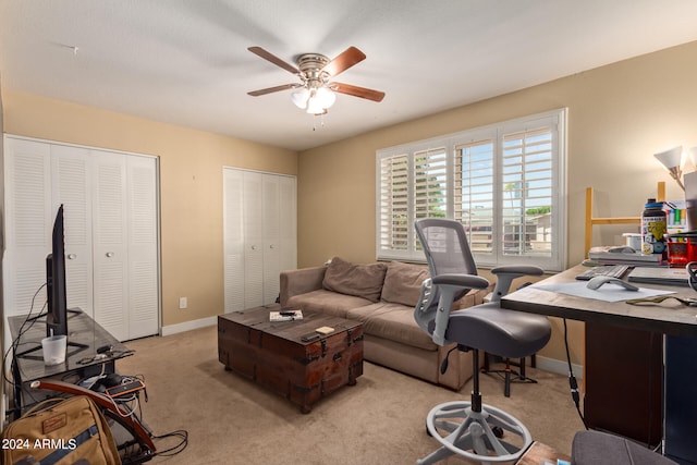 home office featuring light carpet and ceiling fan