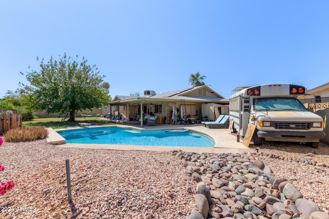 view of pool with a patio and a diving board