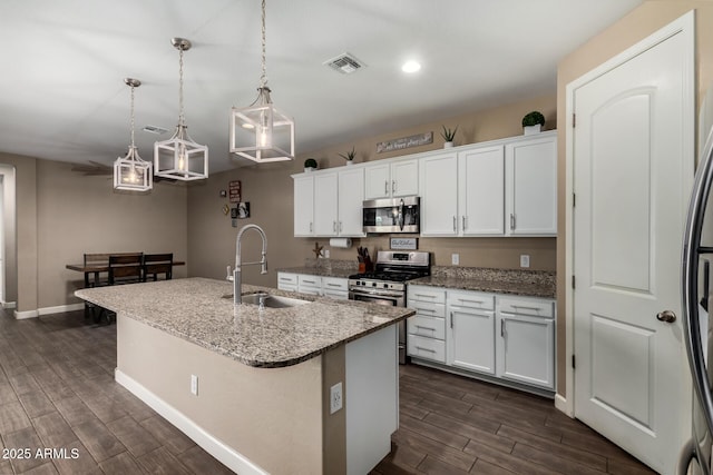 887 W Santa Gertrudis Trl, San Tan Valley, AZ 85143 - kitchen featuring stainless steel appliances, a sink, dark wood-style flooring, a kitchen island with sink, and white cabinetry