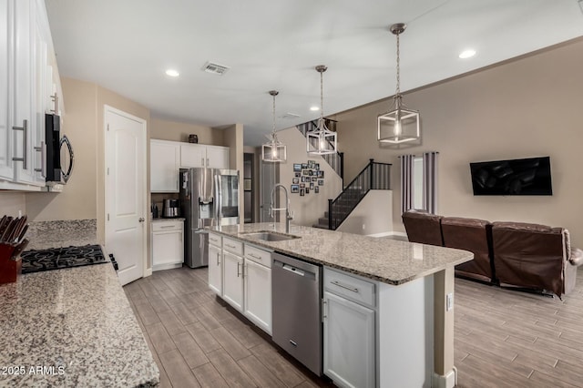 887 W Santa Gertrudis Trl, San Tan Valley, AZ 85143 - kitchen featuring appliances with stainless steel finishes, a sink, light wood finished floors, white cabinets, and recessed lighting