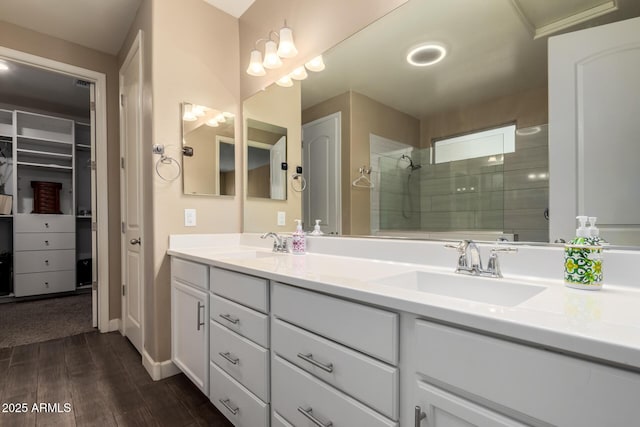 887 W Santa Gertrudis Trl, San Tan Valley, AZ 85143 - bathroom featuring double vanity, a tile shower, wood finished floors, and a spacious closet