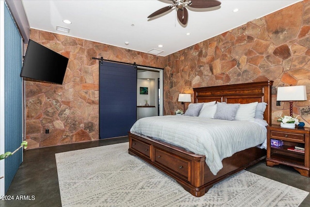 bedroom with ceiling fan and a barn door