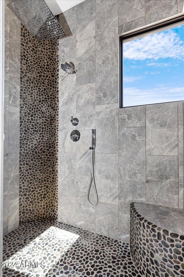 bathroom with a tile shower and plenty of natural light