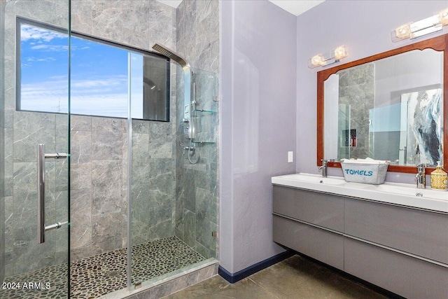 bathroom featuring a shower with door, tile flooring, dual sinks, and vanity with extensive cabinet space