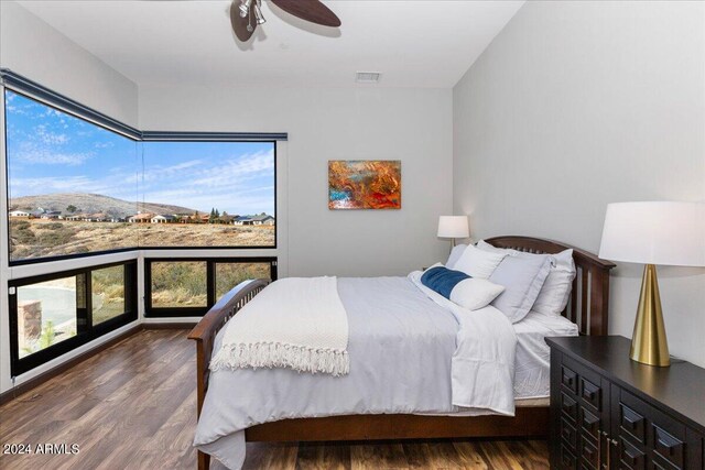 bedroom with dark hardwood / wood-style floors and ceiling fan