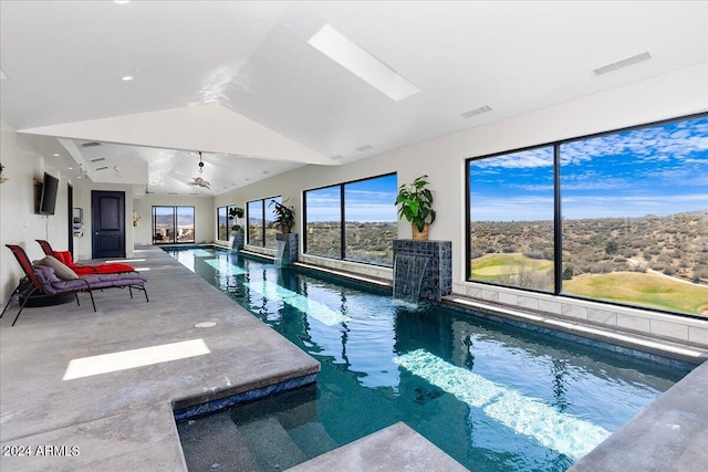 view of swimming pool with a skylight and pool water feature