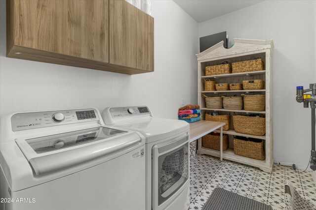 laundry area featuring cabinets and washing machine and clothes dryer