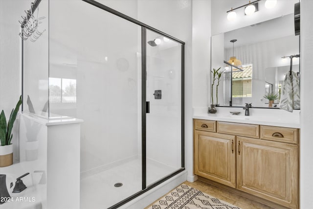 bathroom with tile patterned flooring, a shower with door, and vanity