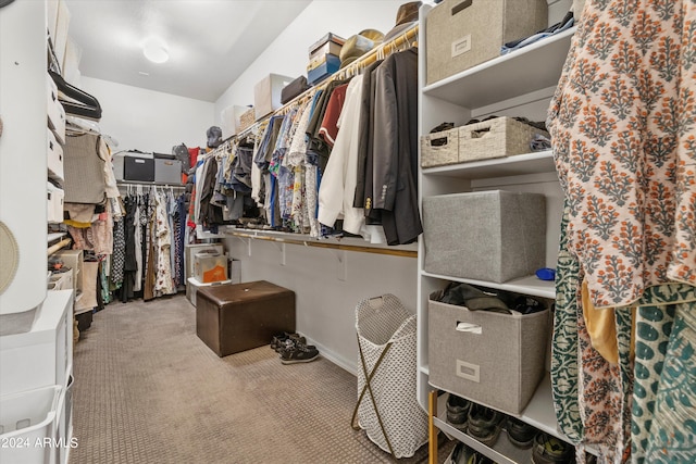 walk in closet featuring light colored carpet