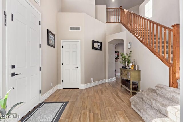 foyer entrance featuring a high ceiling and light hardwood / wood-style flooring