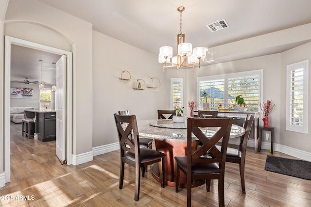 dining area with an inviting chandelier and light hardwood / wood-style flooring