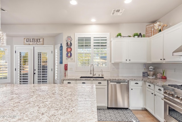 kitchen with sink, white cabinetry, tasteful backsplash, and appliances with stainless steel finishes