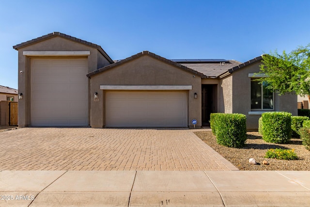 996 W Shannons Way, Coolidge, AZ 85128 - ranch-style home featuring a garage, stucco siding, decorative driveway, roof mounted solar panels, and a tiled roof