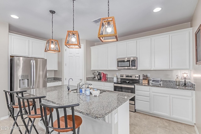 996 W Shannons Way, Coolidge, AZ 85128 - kitchen featuring appliances with stainless steel finishes, a sink, a kitchen bar, white cabinets, and recessed lighting