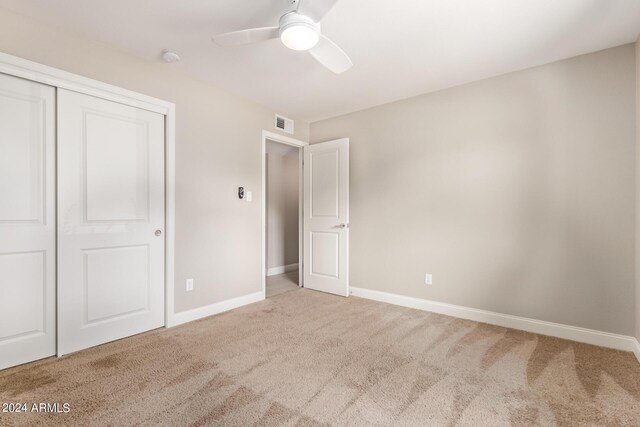 carpeted spare room with ceiling fan