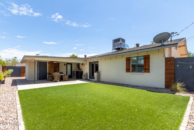 rear view of property with a patio area, a yard, and central AC unit