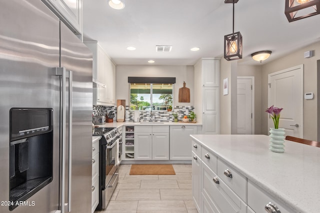 kitchen with decorative light fixtures, stainless steel appliances, white cabinetry, and tasteful backsplash