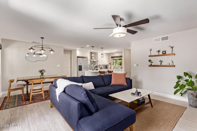 living room with ceiling fan, french doors, and light hardwood / wood-style floors