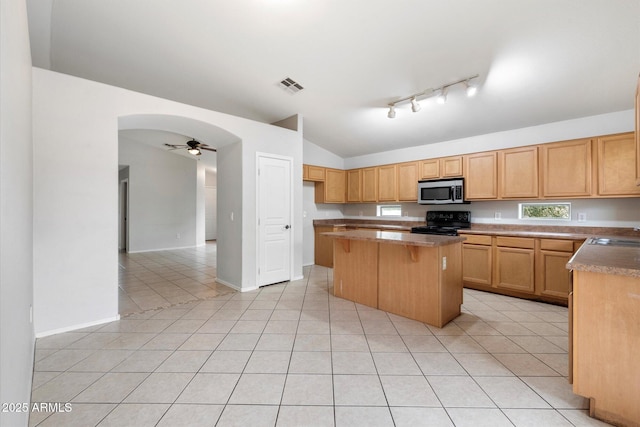 kitchen with vaulted ceiling, a kitchen island, light tile patterned floors, electric range, and ceiling fan