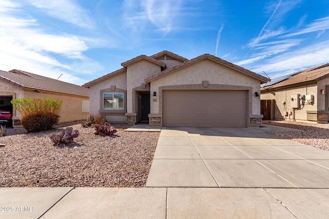 view of front facade with concrete driveway, an attached garage, a tiled roof, and stucco siding