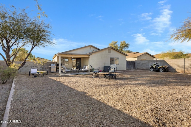 rear view of property with central AC, a patio, and a fire pit