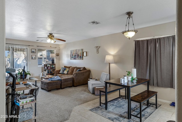 carpeted living room with ceiling fan and a textured ceiling