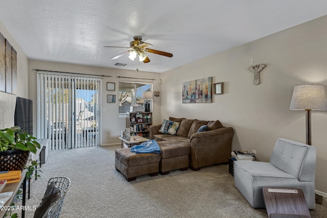 carpeted living room featuring a textured ceiling and ceiling fan