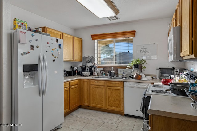 kitchen featuring light tile patterned flooring, white appliances, and sink