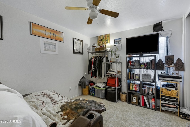 bedroom featuring ceiling fan, carpet floors, and a textured ceiling