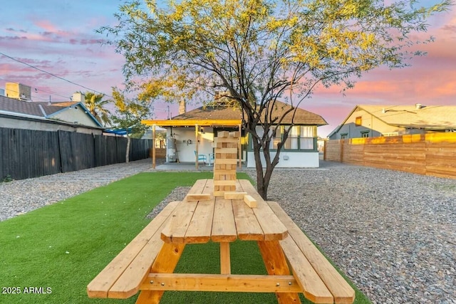 yard at dusk featuring a patio