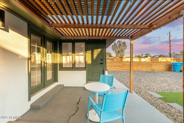 patio terrace at dusk with a pergola and french doors