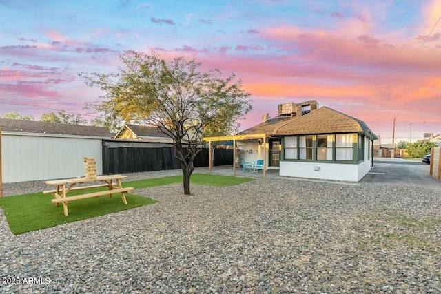 back house at dusk featuring a patio