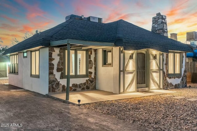 back house at dusk with a patio area and central air condition unit