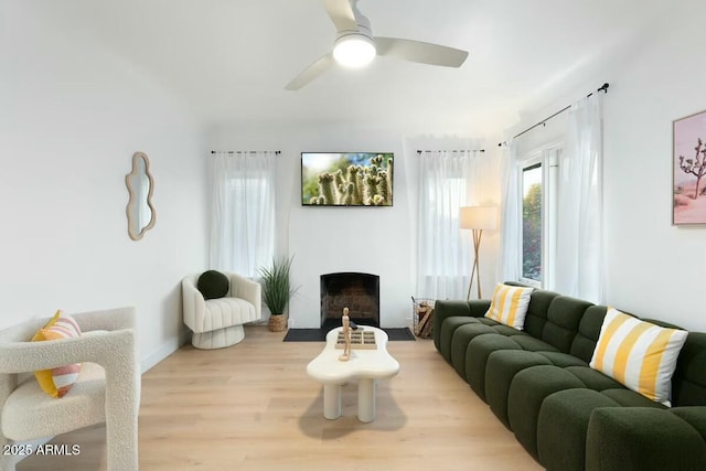 living room featuring ceiling fan and light hardwood / wood-style flooring