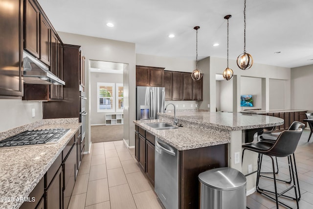 21004 E Sunset Dr, Queen Creek, AZ 85142 - kitchen featuring dark brown cabinets, appliances with stainless steel finishes, under cabinet range hood, a sink, and a center island with sink
