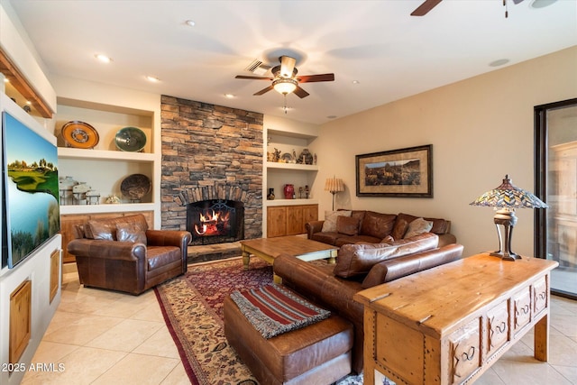 tiled living room featuring built in shelves, ceiling fan, and a fireplace